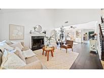 Bright living room with a fireplace, hardwood floors, and neutral decor offers a cozy and inviting space at 4009 Glenlake Nw Trce, Kennesaw, GA 30144