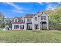 Charming two-story white brick home with manicured lawn and lovely landscaping at 3405 River Ridge, Stockbridge, GA 30281
