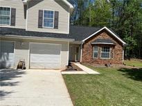 Charming townhome with stone facade, two-car garage, and manicured lawn at 3505 Oakshire Se Way, Atlanta, GA 30354