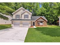 Charming two-story home with a two-car garage, stone accents and a well-manicured lawn at 3505 Oakshire Se Way, Atlanta, GA 30354