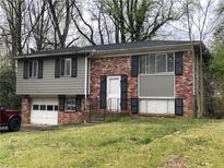 Charming split-level home featuring a brick facade, garage, and manicured lawn at 561 Santa Barbara Dr, Forest Park, GA 30297