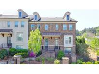 Beautiful brick townhome featuring dormer windows and manicured landscaping at 4007 Dunwoody Trce, Atlanta, GA 30338