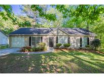 Charming single-story home featuring manicured landscaping, inviting curb appeal, and a one-car garage at 2800 Macon Se Dr, Atlanta, GA 30354