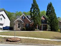 Charming two-story brick home featuring a well-manicured lawn and mature landscaping at 2964 Olivine Dr, Dacula, GA 30019