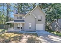Charming two-story home with attached garage and inviting front porch; neutral siding blends with wooded surroundings at 772 Edenton Ct, Jonesboro, GA 30238