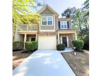 Charming townhome featuring a two-car garage, brick accents, and a cozy front porch at 2333 Castle Keep Way, Atlanta, GA 30316