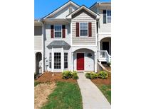Charming townhome featuring a red front door, bay window, and well-maintained landscaping at 73 Timber Ridge Dr, Cartersville, GA 30121
