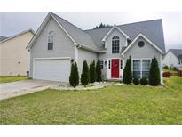 Charming two-story home with a manicured lawn, attached garage, and inviting red front door at 615 Old Johnson Rd, Lawrenceville, GA 30045