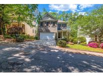 Charming two-story home with a stone and siding facade, a two-car garage, and a well-manicured front yard at 416 Wilfawn Way, Avondale Estates, GA 30002