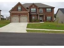 Two-story brick home with a two-car garage and well-maintained lawn at 4623 Shire Dr, Lithonia, GA 30038
