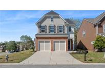 Charming two-story home with a brick and siding exterior, two-car garage, and well-maintained front lawn at 5620 Weddington Drive Dr, Cumming, GA 30040