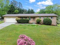 Charming single-story brick home featuring an attached two-car garage and a well-maintained front lawn at 2310 Rubart Dr, Marietta, GA 30066