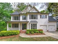Charming two-story home with a covered porch, beautiful landscaping, and a two-car garage at 1043 Middlebrooke Dr, Canton, GA 30115