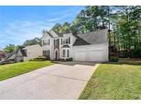 Charming two-story home with a well-manicured lawn, two car garage and elegant architectural details at 1916 Oakwood Grove Dr, Snellville, GA 30078