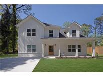 Beautiful two-story home with white siding, a welcoming front porch, and a well-maintained green lawn at 1353 Midlawn Dr, Decatur, GA 30032