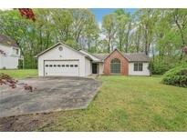 Charming single-story home with a two-car garage, brick accent, and a well-maintained front lawn at 3719 Bomar Rd, Douglasville, GA 30135