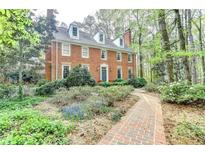Charming red brick two-story home with dormer windows and professionally landscaped front yard at 5884 Hammersmith Rd, Stone Mountain, GA 30087