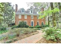 Charming two-story brick home featuring a landscaped yard and a brick walkway leading to the front door at 5884 Hammersmith Rd, Stone Mountain, GA 30087