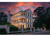 Elegant three-story home featuring inviting balconies and meticulous landscaping at sunset at 3890 The Battery, Duluth, GA 30096