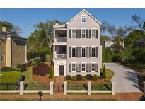 Charming three-story home features black window shutters, dual balconies and a manicured front yard at 3890 The Battery, Duluth, GA 30096