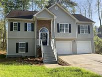 Charming two-story home with a stone entrance, gray siding, black shutters, and a two-car garage at 106 Creek Crossing Ln, Temple, GA 30179