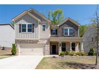 Inviting two-story home with stone and siding exterior, covered entry, and well-manicured front lawn at 1815 Wellston Dr, Lawrenceville, GA 30043