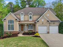 Charming two-story home with manicured lawn, neutral siding, dormer windows, and a two-car garage at 1529 Monarch Dr, Marietta, GA 30062