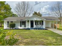Charming single-story home features a covered porch, blue trim, and well-maintained lawn at 262 E Main St, Rutledge, GA 30663