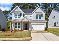 Charming two-story home with a well-manicured lawn, grey brick, and inviting curb appeal at 779 Keystone Dr, Woodstock, GA 30188