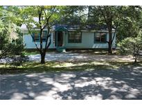 Charming exterior view of a light blue home featuring a well maintained yard and ample trees at 5048 Westbrook Rd, Union City, GA 30291