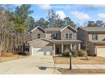 Charming two-story home featuring a brick and stone facade, attached two-car garage, and inviting front porch at 75 Glen Abbey Cir, Fairburn, GA 30213