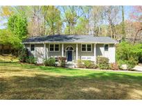 Charming, light grey split-level home with lush, green front yard and mature trees at 133 Cross Gate Dr, Marietta, GA 30068