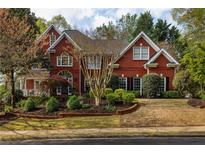 Brick two-story home with manicured landscaping and brick retaining wall at 225 Cotton Field Ct, Alpharetta, GA 30022
