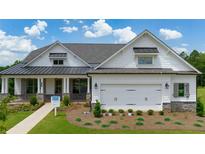 Charming single-Gathering home featuring a two-car garage, stone accents, manicured lawn, and inviting covered porch at 555 Southland Cir, Canton, GA 30115