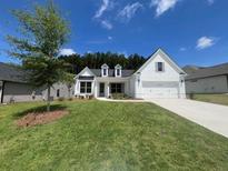 Charming, newly built single-story home with white painted brick, large front yard, and attached two-car garage at 559 Southland Cir, Canton, GA 30115