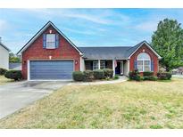 Charming brick home with well-maintained landscaping and a two-car garage at 1965 Winnstead Pl, Loganville, GA 30052