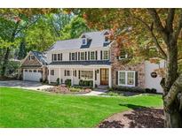 Charming two-story home with a manicured lawn, stone accents, and an attached two-car garage at 4152 Club Ne Dr, Atlanta, GA 30319