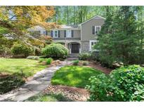Charming two-story home featuring stone accents, manicured lawn and a stone pathway leading to the front door at 5515 Cross Gate Ct, Sandy Springs, GA 30327