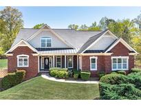 Charming brick home with lush lawn, landscaped shrubbery, and a welcoming front porch at 7804 Gusty Trl, Douglasville, GA 30135