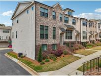 Beautiful brick townhome with manicured lawn and landscaping at 245 Fairview Cir, Roswell, GA 30076