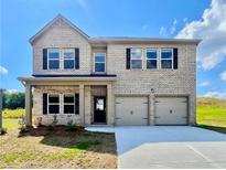 Charming two-story brick home with a two-car garage and well-maintained front yard at 678 Egrets Landing #63, Covington, GA 30014
