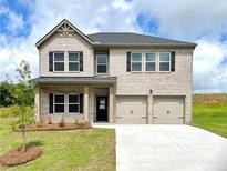 Charming two-story brick home featuring a two-car garage and a neatly landscaped front yard at 678 Egrets Landing #63, Covington, GA 30014