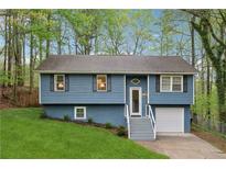 Charming home with blue siding, a well-manicured lawn, and mature trees at 2831 Pine Log Way, Buford, GA 30519