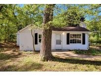Charming single-story home featuring white exterior, black shutters and a well-maintained front yard at 4301 Hidden Valley Rd, Decatur, GA 30035