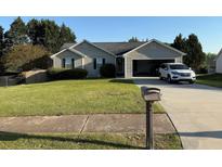 Well maintained single-Gathering home with an attached garage and lush green lawn in a quiet neighborhood at 221 Huntington Dr, Mcdonough, GA 30253