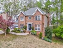 Charming two-story brick home with a well-manicured lawn and beautiful landscaping at 4327 Saint Michaels Dr, Lilburn, GA 30047
