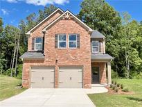 Charming two-story brick home featuring a two-car garage and beautifully landscaped front yard at 657 Egrets Landing #54, Covington, GA 30014