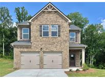 Charming two-story brick home featuring a two-car garage, symmetrical windows, and a welcoming entrance at 657 Egrets Landing #54, Covington, GA 30014
