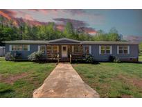 Charming single-story home featuring a covered porch and well-maintained lawn at 537 Craven Rd, Roopville, GA 30170
