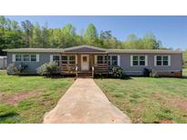 Charming single-story home with a covered front porch, inviting curb appeal and walkway leading to the front door at 537 Craven Rd, Roopville, GA 30170